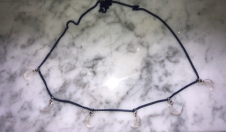 light pink glitter moons on a navy blue chain