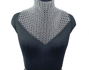 May include: A silver chainmail collar necklace. The chainmail is made of small, interlocking metal rings. The collar is displayed on a black mannequin.