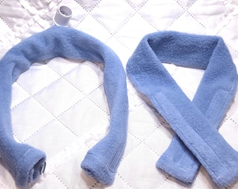 Può includere: Due scaldacollo in pile blu, uno con un connettore in plastica bianca all'estremità.