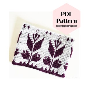 Puede incluir: Patrón de ganchillo para un diseño floral morado y blanco. El patrón está disponible para descargar en PDF en hobbyistontheroad.com.