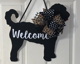 May include: Black silhouette of a dog with the word "Welcome" written on it. The dog is decorated with a leopard print and black and white polka dot bow.