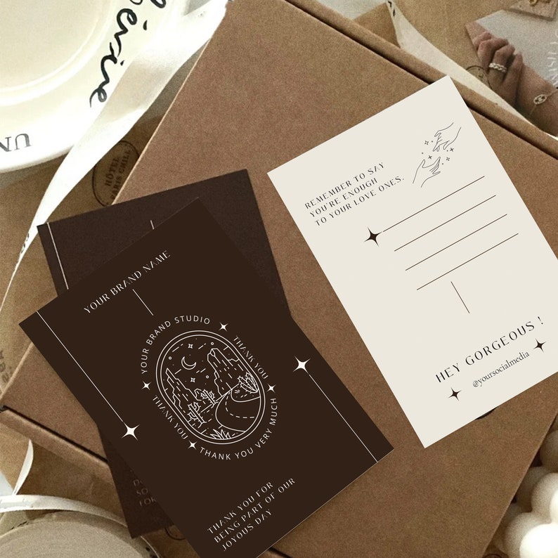 May include: A brown card with a white design of a landscape with a moon and stars. The text on the card reads "Your Brand Studio" and "Thank You Very Much". The card also includes the text "Remember to say you're enough to your love ones." and "Hey Gorgeous! @yoursocialmedia".