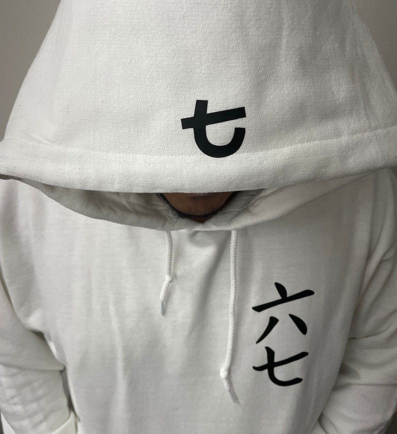 May include: White hooded sweatshirt with black Japanese characters on the hood and chest. The hood features a single character, while the chest displays three characters. The sweatshirt has white drawstrings.