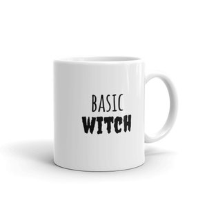 Könnte beinhalten: Weiße Keramik-Kaffeetasse mit schwarzem Text, der "BASIC WITCH" lautet.