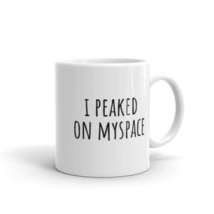 May include: White ceramic coffee mug with black text that reads "I peaked on Myspace".
