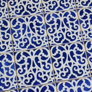 May include: A pattern of blue and white ceramic tiles with a decorative, intricate design. The tiles are arranged in a grid pattern.