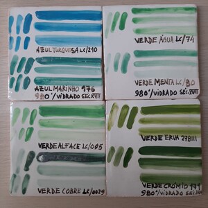 May include: Four ceramic tiles with painted stripes in shades of blue and green. Each tile has a label with the color name and a code, such as "AZUL TURQUESA LC/210" and "VERDE &Aacute;GUA LC/74".