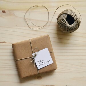 Peut inclure: Un sac cadeau en papier brun attach&eacute; avec de la ficelle et une &eacute;tiquette cadeau blanche sur laquelle est inscrit "Helen Gutteridge".