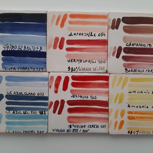 May include: Six ceramic tiles with color swatches of blue, red, orange, and brown paint. Each tile has a label with the name of the color and the paint number. The tiles are arranged in two rows of three.