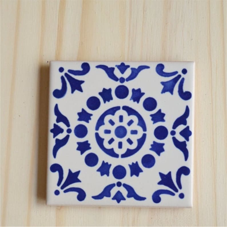 Peut inclure: Un carreau de c&eacute;ramique blanc avec un motif g&eacute;om&eacute;trique bleu et blanc. Le motif pr&eacute;sente un motif floral central entour&eacute; de cercles et d'&eacute;toiles.