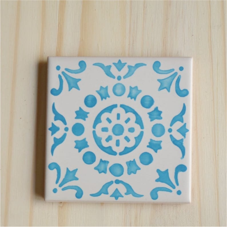 Peut inclure: Un carreau de c&eacute;ramique blanc avec un motif g&eacute;om&eacute;trique bleu et blanc. Le motif pr&eacute;sente un motif floral central entour&eacute; de petits cercles et &eacute;toiles.