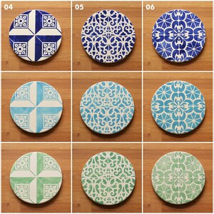May include: Nine different round ceramic tiles with blue and white geometric patterns. The tiles are arranged in three rows of three, with each tile having a unique design.