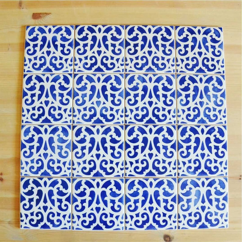May include: A set of 18 blue and white ceramic tiles with a decorative, intricate, floral pattern. The tiles are arranged in a grid pattern.