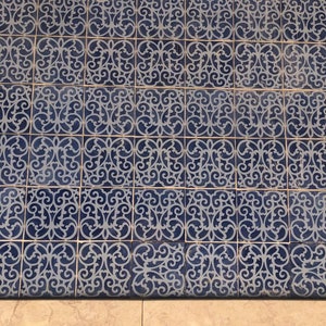 May include: A close-up of a tiled floor with a repeating pattern of blue and white intricate designs. The tiles are arranged in a grid pattern, creating a symmetrical and visually appealing surface.