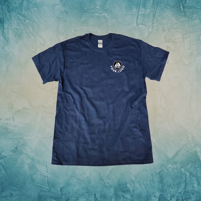 Peut inclure: Un t-shirt bleu fonc&eacute; avec un logo blanc qui dit "YOUR LOGO" dans un cercle.