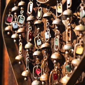 Handcrafted heart wind chime featuring colorful hanging dangles and decorative metal bells with a beautiful flamed finish. Metal wind chimes outdoor designed for garden decor, patio accents, porch decoration, balconies, fences, and backyard landscapes. Heart-shaped hanging garden ornament creates gentle, relaxing sounds while adding artistic charm to outdoor spaces. Perfect farmhouse decor, metal garden art, yard art, housewarming gift, romantic garden decor, and year-round outdoor decoration.