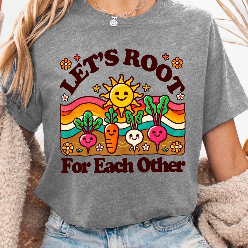 May include: Gray t-shirt with a graphic of a smiling sun and cartoon vegetables with the text "Let's Root For Each Other".