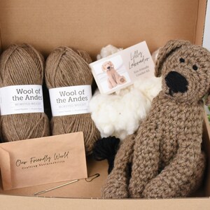 May include: A brown crochet kit for making a Labrador puppy. The kit includes two balls of brown yarn, a bag of white stuffing, a crochet hook, a needle, and a pattern. The pattern is labeled "Lilly Labrador Fine Crochet Kit".