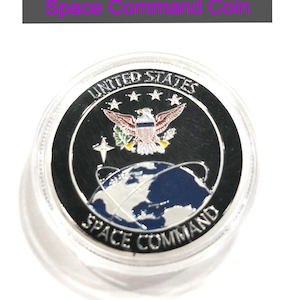 May include: A silver coin with a black background featuring the United States Space Command logo. The logo includes a globe with a blue and white design, a bald eagle with a red, white, and blue design, and five stars. The text "UNITED STATES SPACE COMMAND" is printed around the globe.