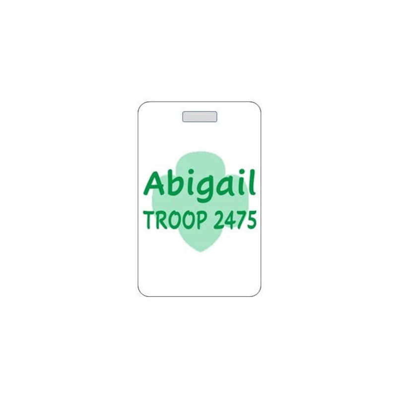 May include: White rectangular tag with a green four-leaf clover shape. The tag says "Abigail TROOP 2475" in green text.