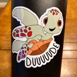 May include: A black water bottle with a sticker of a cartoon turtle with red spots and the text "DUUUUUDE".