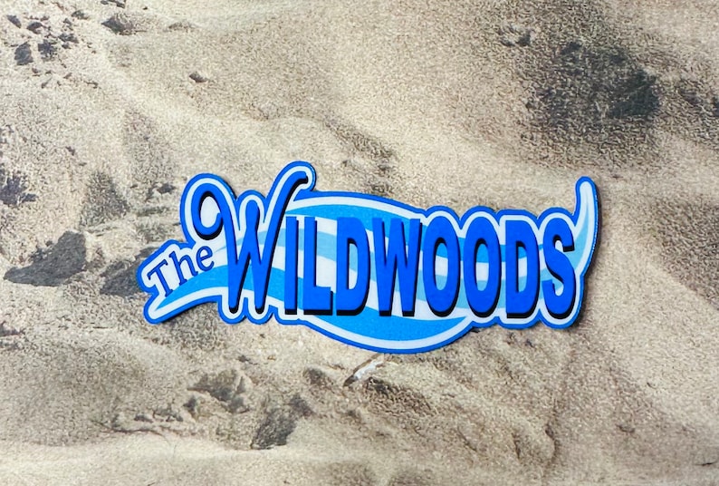 Puede incluir: Un logotipo azul y blanco con el texto "The Wildwoods" sobre un fondo arenoso.