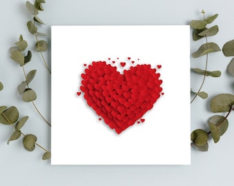 May include: A white card with a red heart made of smaller red hearts. The heart is surrounded by smaller red hearts. The card is on a light blue background with green leaves on either side.
