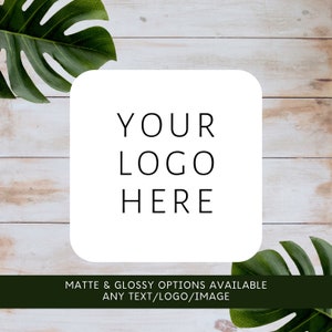 May include: White square with rounded corners on a wood background with green leaves. The square has the text "YOUR LOGO HERE" in black. The text below the square reads "MATTE & GLOSSY OPTIONS AVAILABLE ANY TEXT/LOGO/IMAGE".