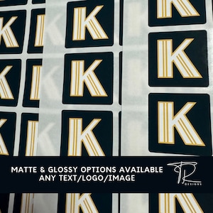 May include: A sheet of stickers with a gold letter K on a black background. The text "Matte & Glossy Options Available Any Text/Logo/Image" is at the bottom of the image.