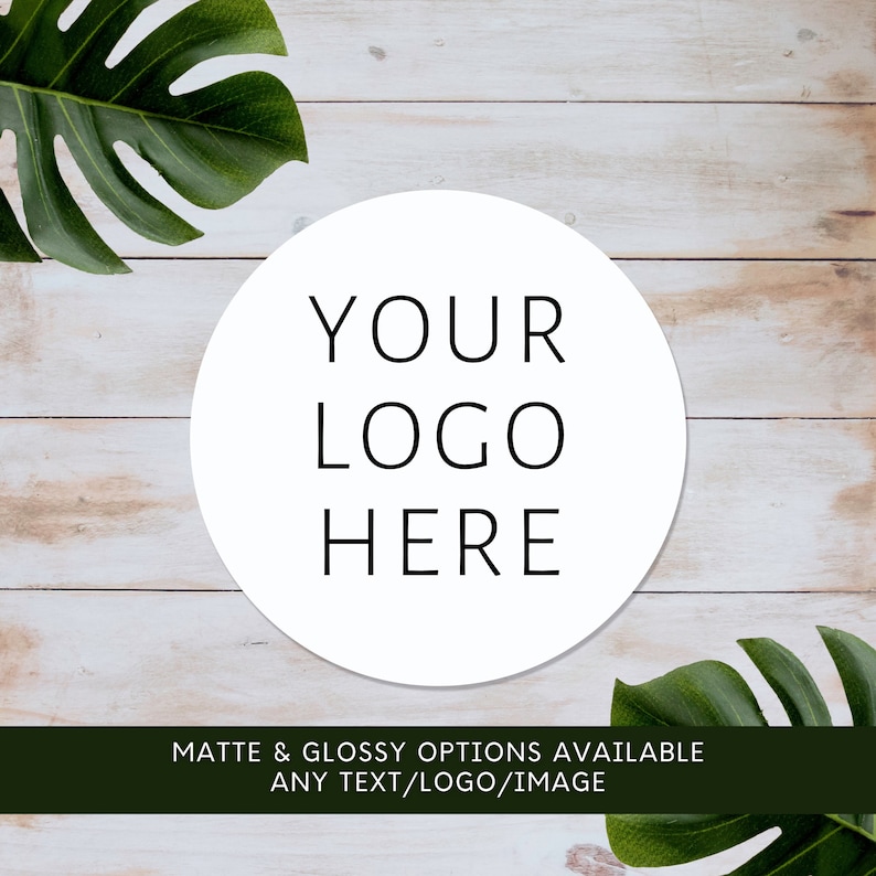 May include: A circular white sticker featuring the black text YOUR LOGO HERE centered in the middle. The sticker is displayed against a light wood grain background with green monstera leaves in the corners and a dark bar with white text.