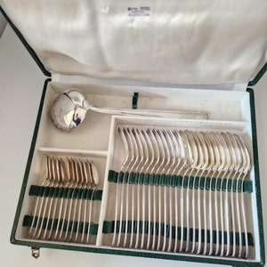 Peut inclure: Une boîte doublée de velours vert contenant un ensemble de couverts en argent. L'ensemble comprend une louche et des fourchettes.