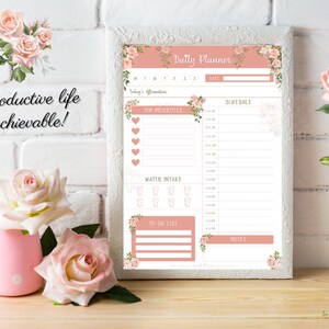 May include: A printable daily planner with a pink floral design. The planner includes sections for scheduling, top priorities, water intake, to-do list, and notes. The text "Daily Planner" is at the top of the page.