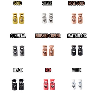 Puede incluir: Colección de topes para cordón en varios colores metálicos y lisos, incluyendo dorado, plateado, oro rosa, metal de cañón, cobre cepillado, negro mate, negro, rojo y blanco. Cada par se muestra sobre un fondo blanco.