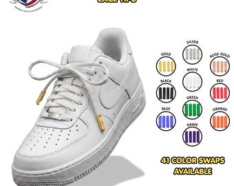 May include: A white sneaker with gold screw-on metal aglets attached to the laces. The image displays the text "SCREW ON METAL AGLETS LACE TIPS" and "41 COLOR SWAPS AVAILABLE" alongside a color chart showing gold, silver, rose gold, white, black, red, blue, green, orange, and grape options.