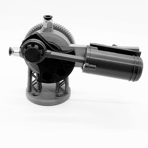 May include: A grayscale mechanical device with a circular gear, a cylindrical component, and a support structure. The device has a complex design with multiple connecting parts and appears to be 3D-printed. The base is round with three holes.