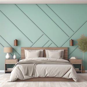 Op de afbeelding: Een licht houten bedframe met een wit hoofdeinde en een wit dekbedovertrek. Het bed is opgemaakt met een bruin dekentje en twee witte kussens. De muur achter het bed is lichtgroen geverfd en heeft een geometrisch patroon.