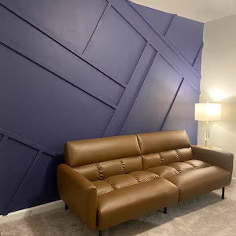 Brown couch in front of blue dimensional accent wall.
