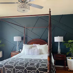 Four poster bed in front of dark dimensional accent wall