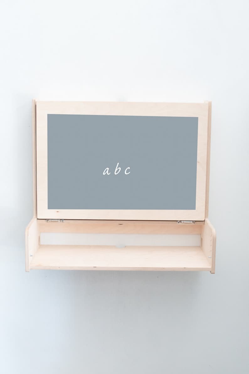 May include: A light wood shelf with a hinged chalkboard panel that says "abc".