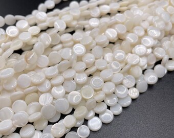 Peut inclure: Un brin de perles rondes en coquillage blanc. Les perles sont lisses et ont un léger éclat iridescent.