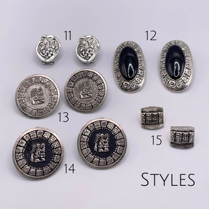 May include: Assortment of silver tone earrings and charms with Aztec inspired designs. The earrings feature black onyx stones and the charms have intricate details. The charms are numbered 11, 12, 13, 14, and 15. The text "STYLES" is written below the charms.