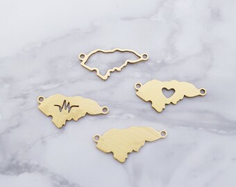 May include: Four gold-colored metal charms shaped like the island of Jamaica. One charm has a heartbeat design, one has a heart cut-out, and two are solid.