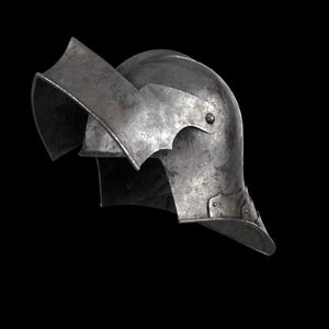 May include: A weathered, metallic helmet with a curved visor and neck guard. The helmet has a riveted construction and a slightly tarnished finish, suggesting age and use. The design is reminiscent of medieval armor.