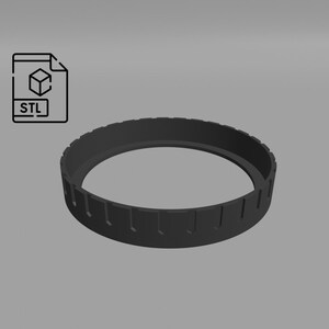 May include: A black plastic ring with a series of evenly spaced grooves around the outer edge.
