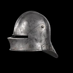 May include: A weathered, steel helmet with a rounded top and a visor. The helmet has a riveted construction and a dark, aged appearance. The visor is slightly angled, and the helmet appears to be of medieval design.