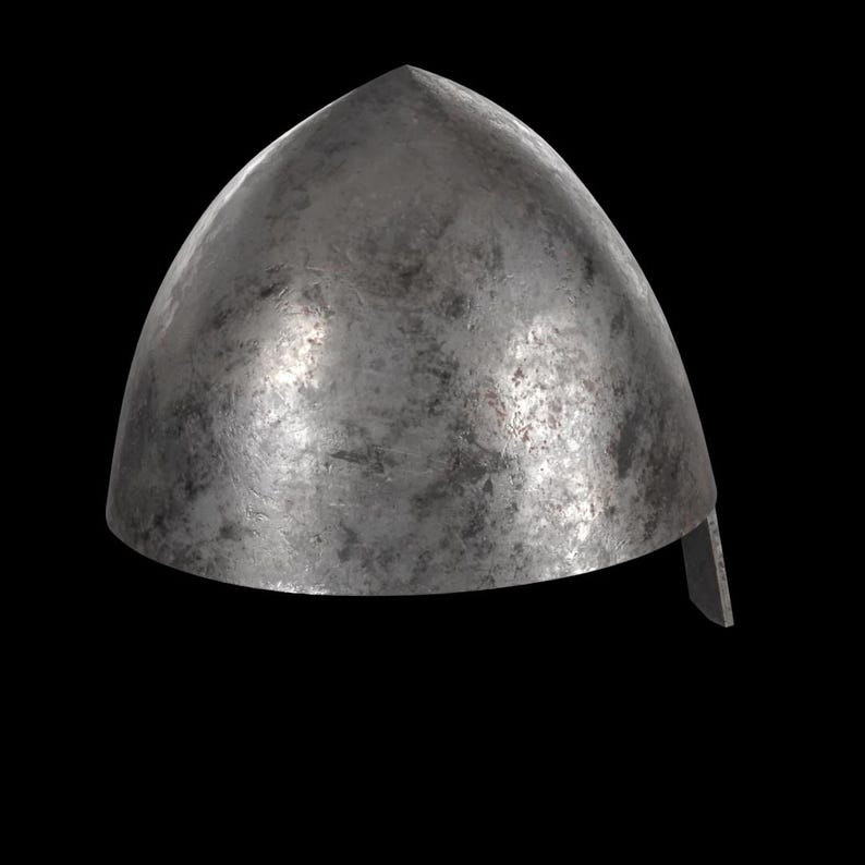 May include: A weathered, metallic helmet with a pointed top and a curved, domed shape. The helmet has a slightly textured surface and a small, rectangular piece extending from the lower edge. The background is black.