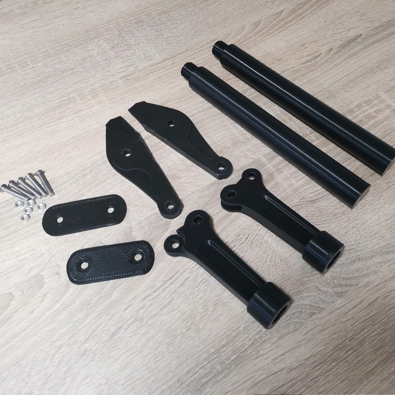 Puede incluir: Un conjunto de piezas impresas en 3D de color negro para una motocicleta, que incluye dos varillas largas, dos soportes curvos, dos placas planas y un peque&ntilde;o juego de tornillos.