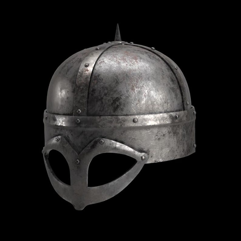 May include: A weathered, metallic Viking helmet with a prominent brow guard and a single, pointed spike at the crown. The helmet features riveted bands and a visor with eye openings, showcasing a historical design.