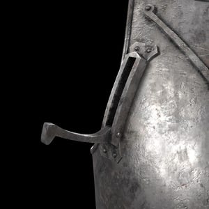 K&ouml;nnte beinhalten: Ein metallisches, verwittertes Stahlpanzerungsteil mit einer texturierten, narbigen Oberfl&auml;che. Ein markanter, gebogener Metallhaken ragt aus einem rechteckigen Geh&auml;use hervor, das mit Nieten am Hauptk&ouml;rper des St&uuml;cks befestigt ist.