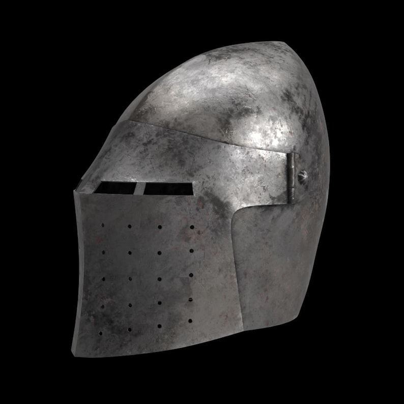 May include: A weathered, steel-colored medieval helmet with a rounded top and a face guard. The helmet features a horizontal eye slit and a series of small ventilation holes. A hinge is visible on the side. The background is black.